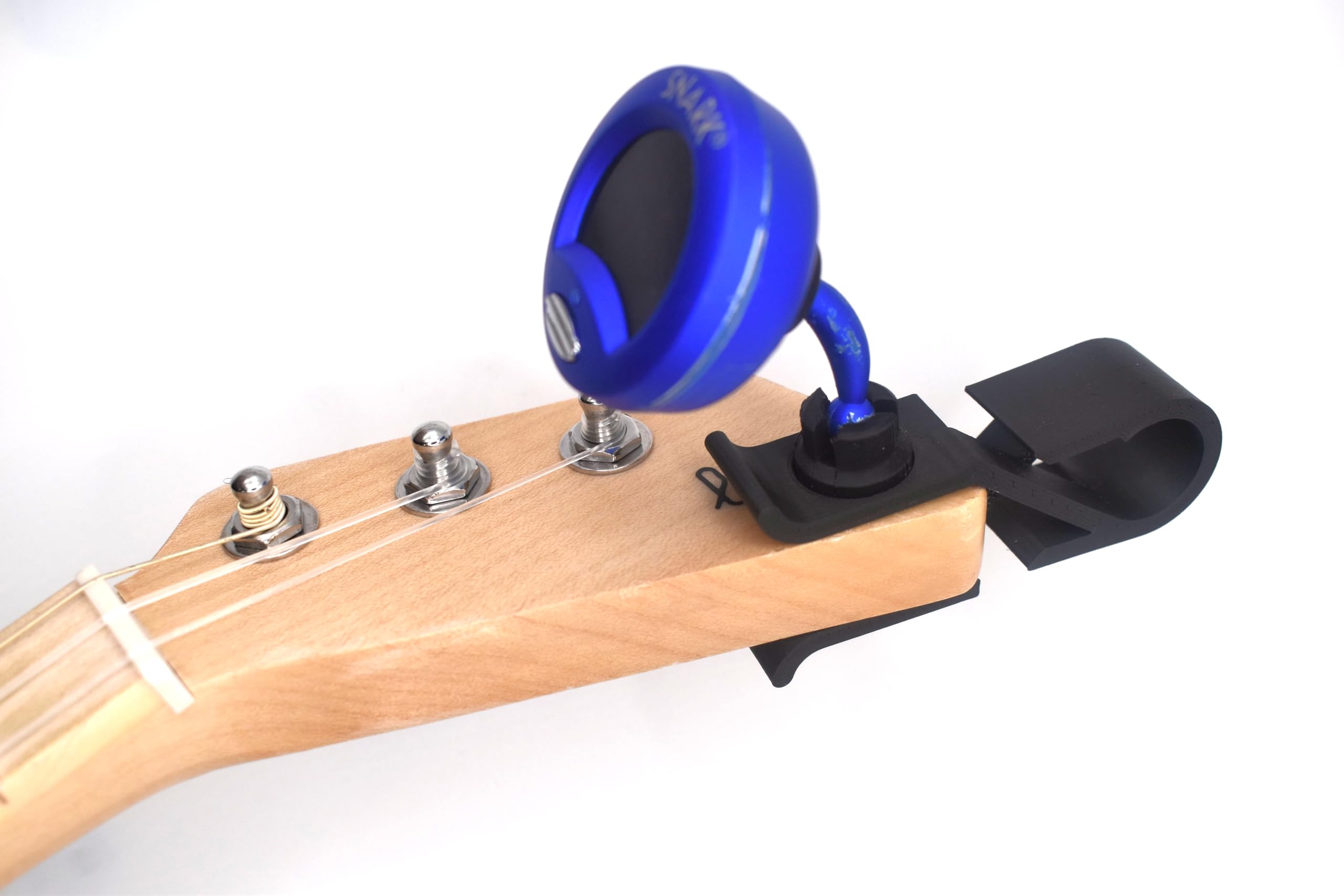 A 3D-printed replacement clip attached to a Snark tuner and clipped onto the neck of a guitar.